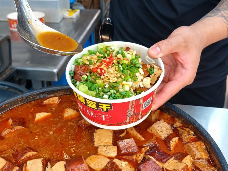 廟東夜市美食從滷製開始 大黑豆干先吸入滷汁 再以自製配方堆出蒜香風味 廟東夜市美食從滷製開始 大黑豆干先吸入滷汁 再以自製配方堆出蒜香風味